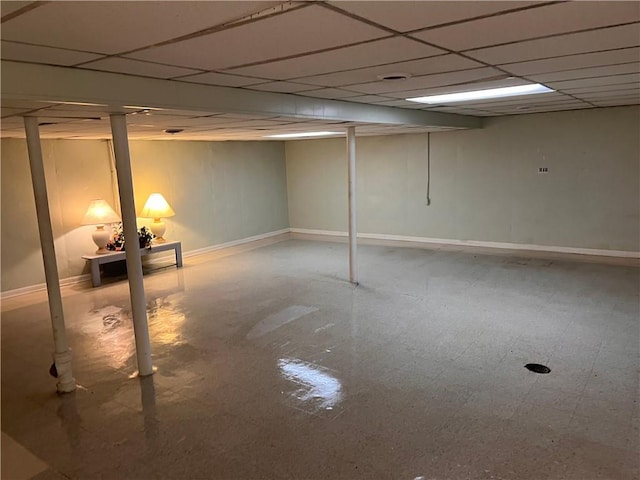 finished below grade area with a drop ceiling and baseboards