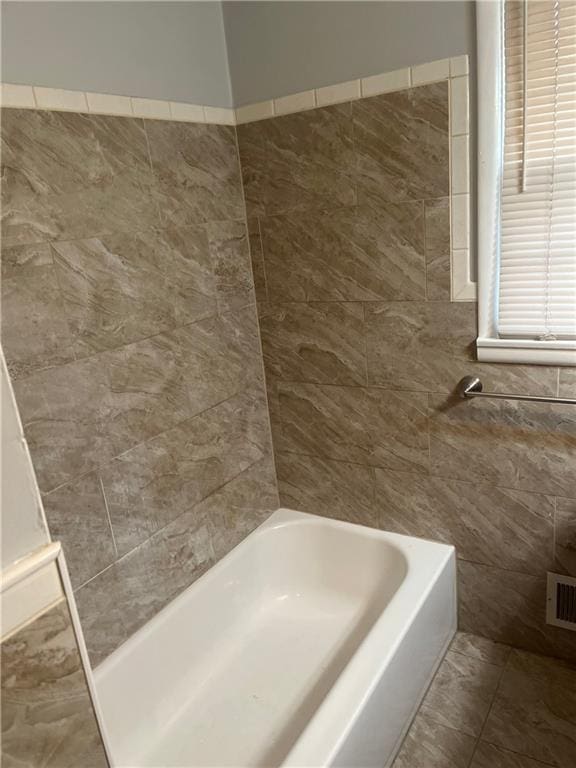 full bath with a shower, visible vents, tile walls, and a tub to relax in
