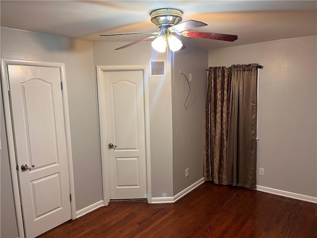 unfurnished bedroom with visible vents, baseboards, dark wood-style floors, and a ceiling fan