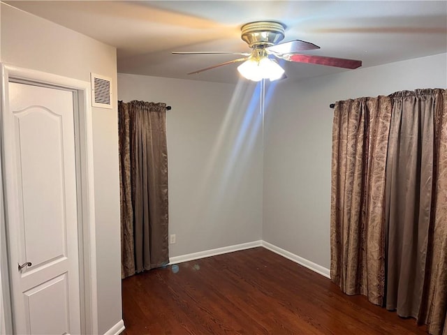 unfurnished room with wood finished floors, a ceiling fan, visible vents, and baseboards