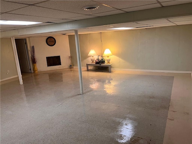 finished below grade area featuring baseboards, a paneled ceiling, and visible vents