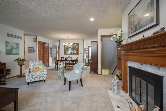 327 E Partridge Ave, Independence, MO 64055 - living room with light carpet, visible vents, a textured ceiling, and a notable chandelier