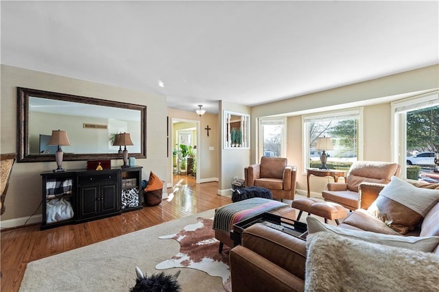 living room featuring baseboards, wood finished floors, and visible vents