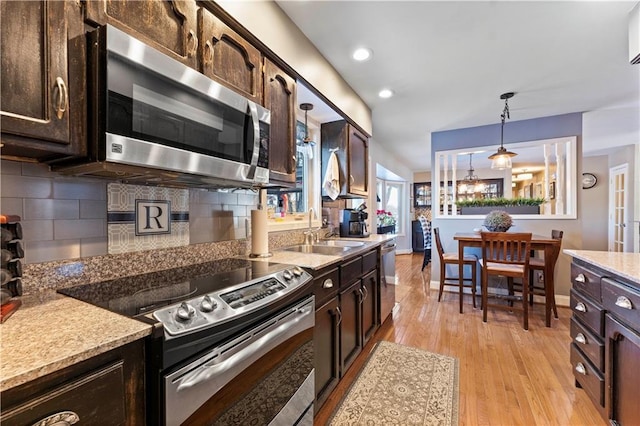 kitchen with a sink, appliances with stainless steel finishes, dark brown cabinetry, and tasteful backsplash