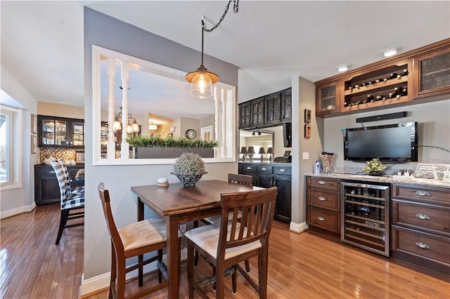 dining room featuring light wood-style floors, baseboards, and beverage cooler