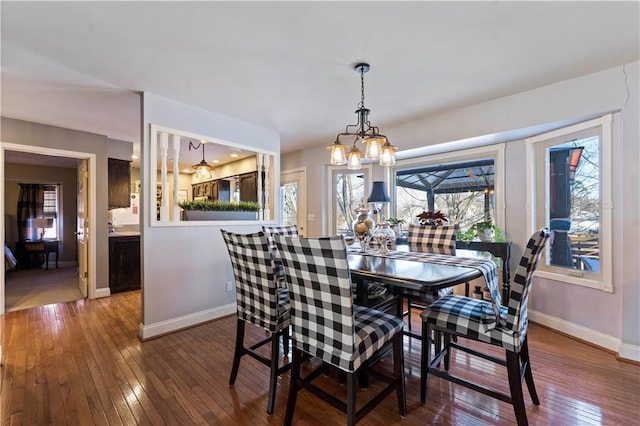 dining room featuring an inviting chandelier, baseboards, and wood-type flooring