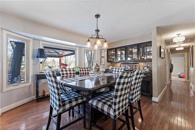 dining space featuring baseboards and dark wood-style floors