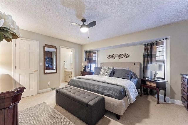 bedroom featuring ceiling fan, light carpet, baseboards, ensuite bathroom, and visible vents
