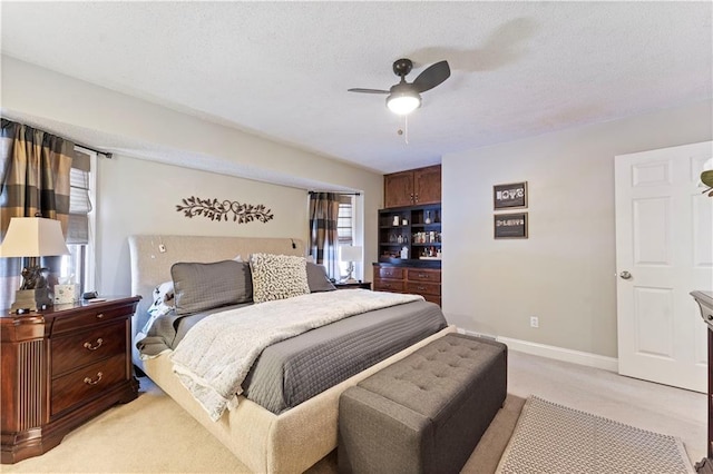 bedroom featuring baseboards, light carpet, and ceiling fan