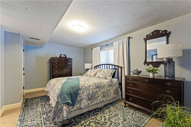 bedroom with baseboards, carpet flooring, a textured ceiling, and visible vents