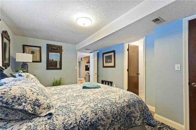 bedroom with visible vents, a textured ceiling, and baseboards