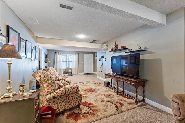 carpeted living area featuring baseboards, a textured ceiling, and visible vents