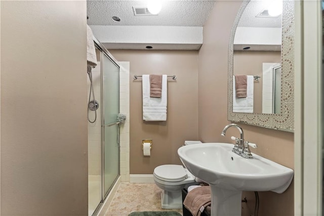 bathroom with baseboards, a textured ceiling, toilet, and a shower stall
