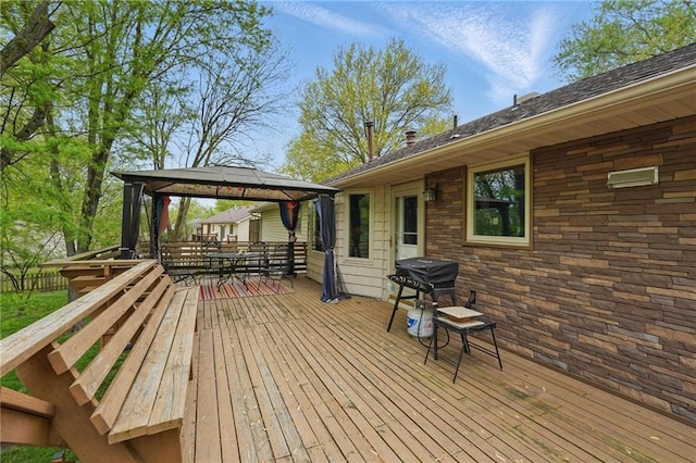 wooden deck featuring a gazebo, outdoor dining area, and a grill