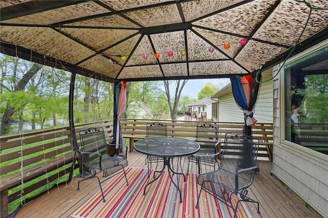 wooden deck featuring a gazebo and outdoor dining area