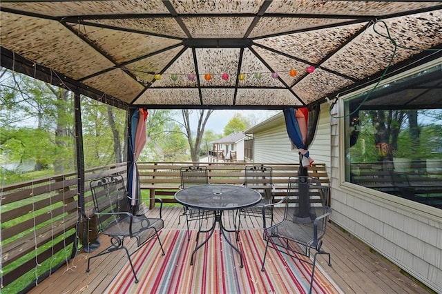 wooden deck featuring a gazebo and outdoor dining area