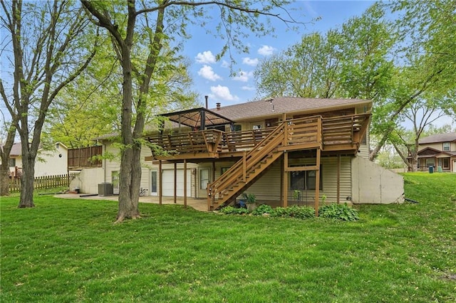 rear view of property with fence, a deck, stairway, central air condition unit, and a yard