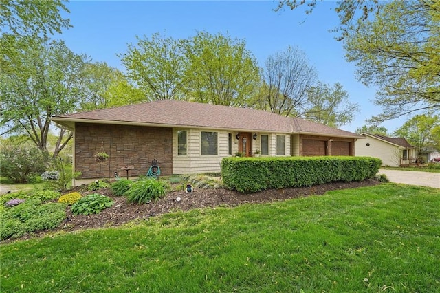 view of front of property featuring an attached garage, a front lawn, driveway, and stone siding