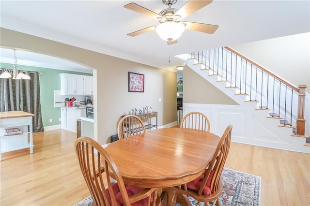4373 Hackberry Ln, Bates City, MO 64011 - dining area with light wood finished floors, ornamental molding, stairs, a ceiling fan, and arched walkways