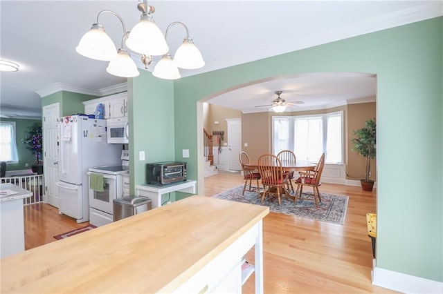 4373 Hackberry Ln, Bates City, MO 64011 - kitchen featuring white appliances, arched walkways, ornamental molding, decorative light fixtures, and light wood finished floors