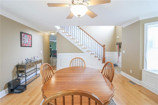 4373 Hackberry Ln, Bates City, MO 64011 - dining room featuring stairs, ornamental molding, light wood-style flooring, ceiling fan, and a decorative wall