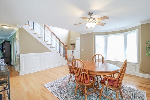4373 Hackberry Ln, Bates City, MO 64011 - dining space featuring crown molding, stairs, light wood-style flooring, ceiling fan, and a decorative wall
