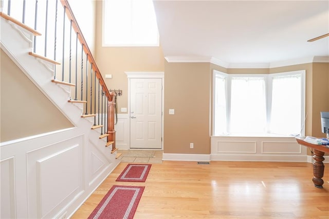 4373 Hackberry Ln, Bates City, MO 64011 - foyer entrance with light wood-style flooring, ornamental molding, stairway, a ceiling fan, and a decorative wall