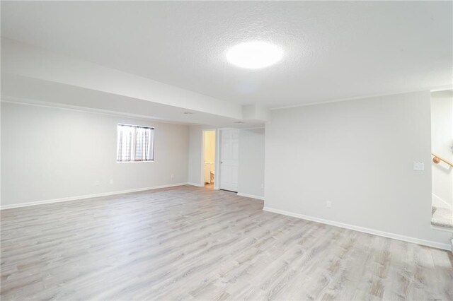 4373 Hackberry Ln, Bates City, MO 64011 - below grade area with light wood-style floors, a textured ceiling, and baseboards
