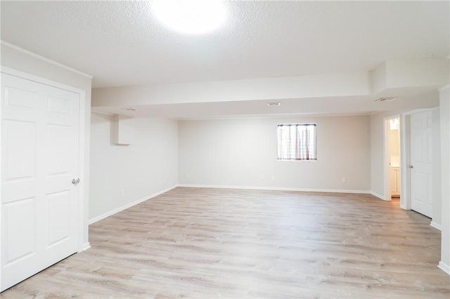 4373 Hackberry Ln, Bates City, MO 64011 - below grade area featuring light wood-style floors, baseboards, and a textured ceiling