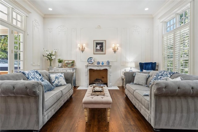 living room featuring recessed lighting, dark wood finished floors, and a decorative wall