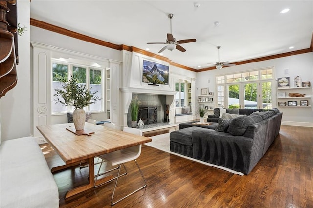living area with ceiling fan, a high end fireplace, dark wood-style floors, ornamental molding, and recessed lighting
