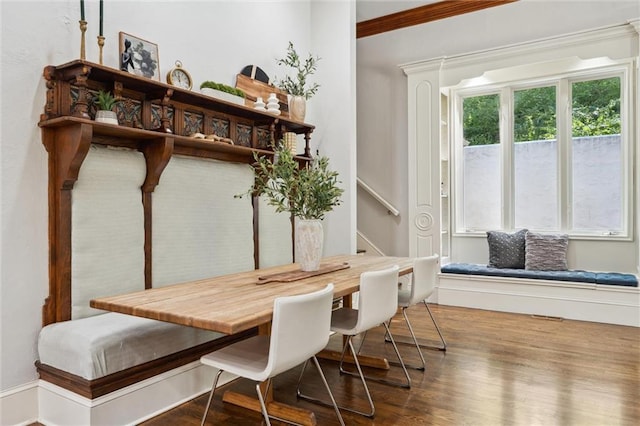 dining room featuring ornamental molding, stairs, and wood finished floors