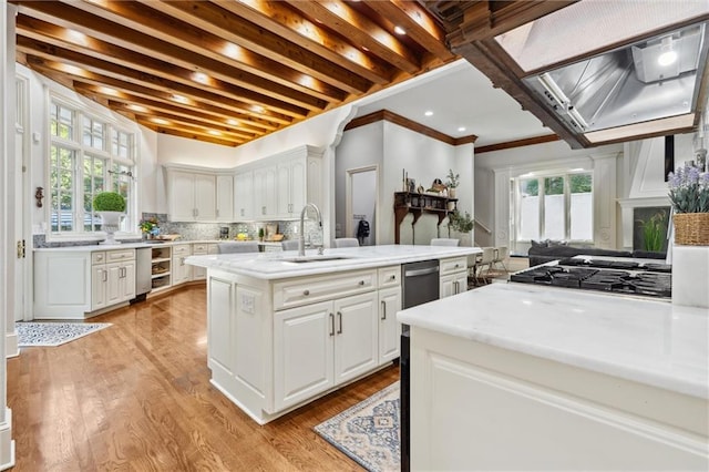 kitchen featuring light countertops, a sink, white cabinets, and tasteful backsplash