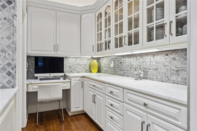 kitchen featuring white cabinetry, tasteful backsplash, glass insert cabinets, and dark wood-type flooring