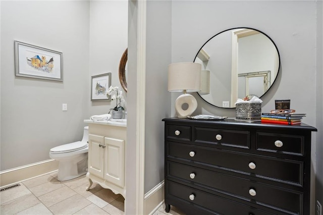 half bath with vanity, toilet, tile patterned floors, baseboards, and visible vents