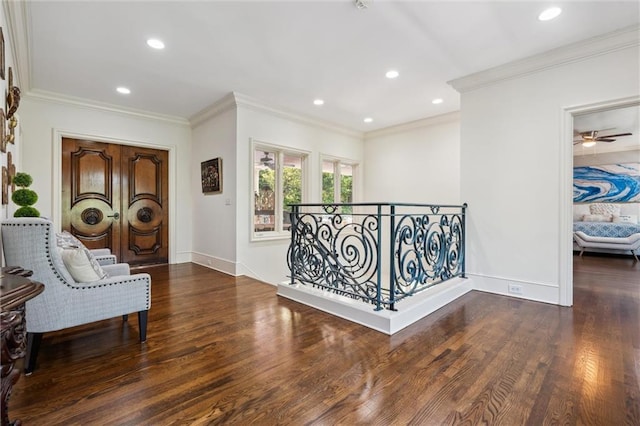 living area with baseboards, ornamental molding, and wood finished floors