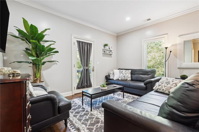 living area featuring plenty of natural light, ornamental molding, baseboards, and wood finished floors