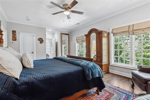 bedroom featuring a ceiling fan, baseboards, wood finished floors, visible vents, and ornamental molding