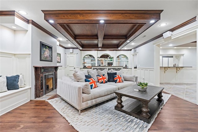 living area with ornamental molding, a decorative wall, beamed ceiling, coffered ceiling, and a premium fireplace