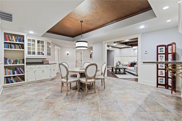 dining area featuring crown molding, a raised ceiling, recessed lighting, and visible vents