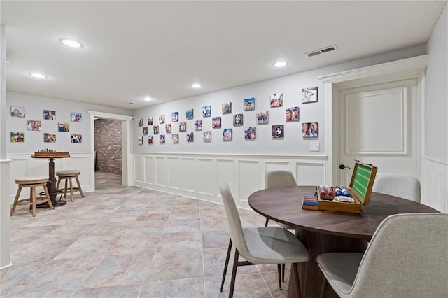 dining room featuring a wainscoted wall, a decorative wall, recessed lighting, and visible vents