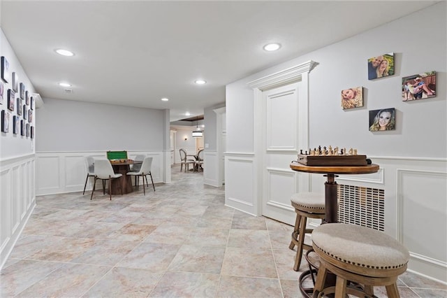 dining space with a wainscoted wall, a decorative wall, and recessed lighting