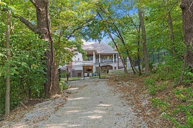 view of front of property with fence and dirt driveway