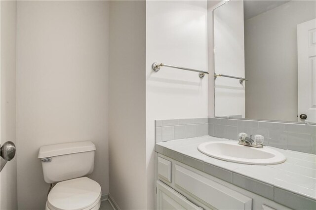 22804 E 28th Terrace Ct, Blue Springs, MO 64015 - bathroom featuring toilet, vanity, and baseboards
