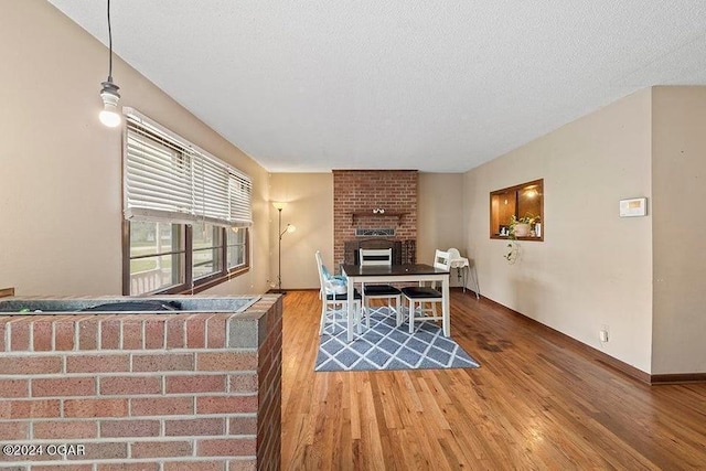 104 W Highland Ave, Nevada, MO 64772 - home office featuring a fireplace, wood finished floors, and a textured ceiling