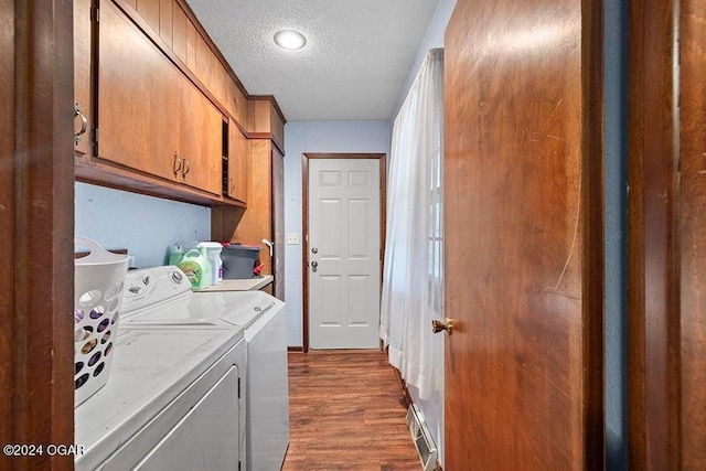 104 W Highland Ave, Nevada, MO 64772 - washroom with dark wood-type flooring, independent washer and dryer, a textured ceiling, and cabinet space