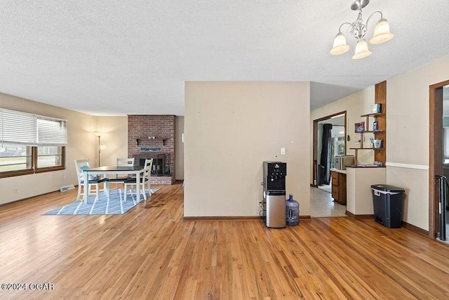 104 W Highland Ave, Nevada, MO 64772 - dining room featuring light wood-type flooring, a chandelier, and a textured ceiling