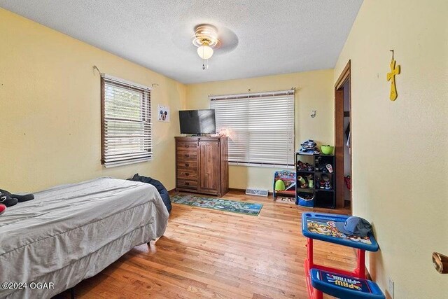 104 W Highland Ave, Nevada, MO 64772 - bedroom featuring visible vents, a textured ceiling, and wood finished floors