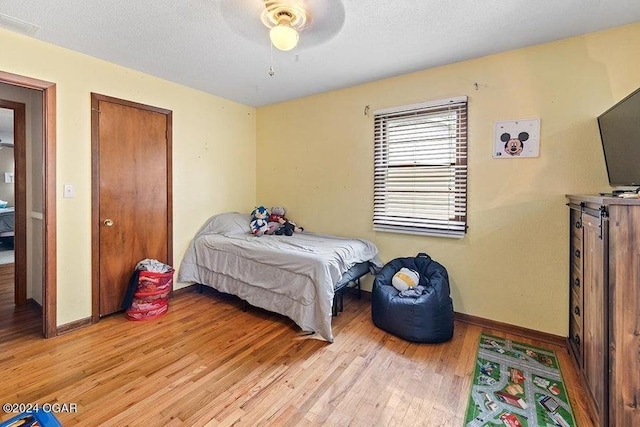 104 W Highland Ave, Nevada, MO 64772 - bedroom featuring light wood-style floors, baseboards, and a textured ceiling