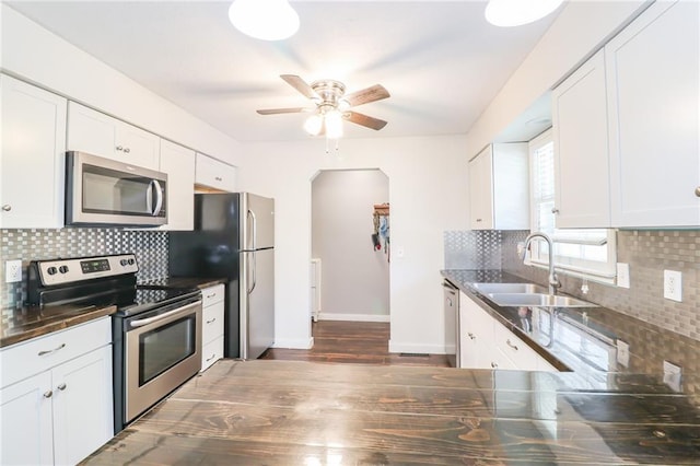 308 Acorn Pl, Warrensburg, MO 64093 - kitchen featuring appliances with stainless steel finishes, dark countertops, backsplash, a ceiling fan, and dark wood-style floors